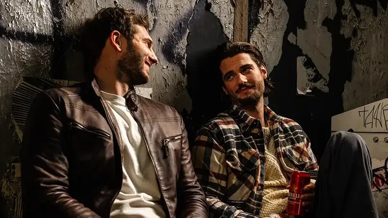 Scene from A Night Like This featuring Lukas and Oliver sharing a meaningful conversation as their unexpected romance begins to unfold.