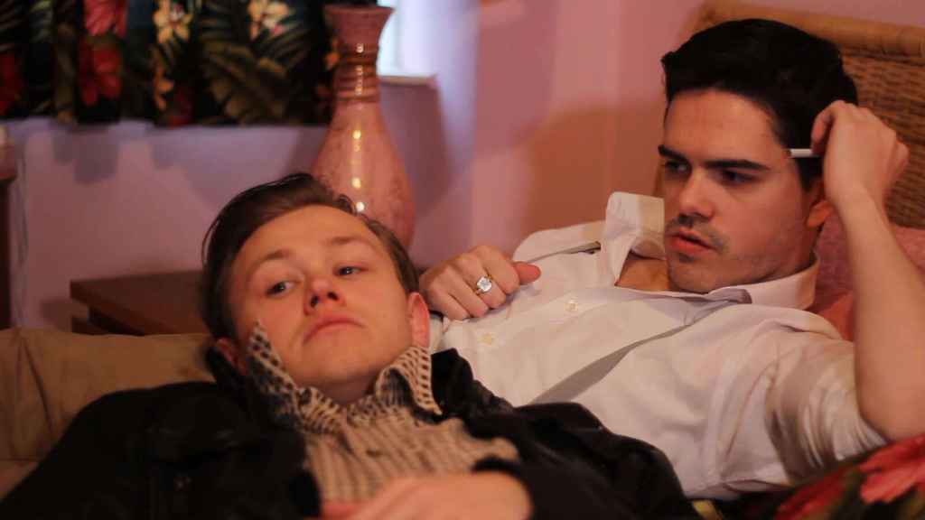 Tommy and Eddy share a quiet moment together in Once a Year on Blackpool Sands, a historical LGBTQ+ romance film streaming on Dekkoo.