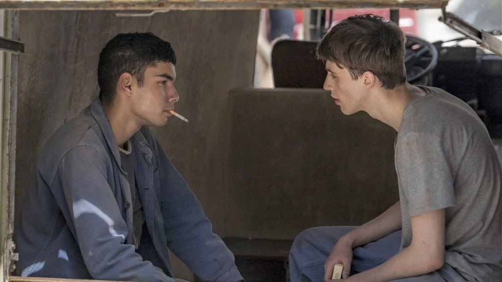 Two young men share a private conversation inside a vehicle in the French LGBTQ+ drama series PROUD.