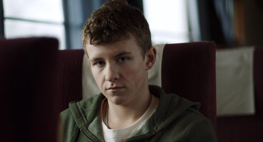 Oskar sits alone on an overnight train in a scene from The Night Train, Jerry Carlsson's award-winning LGBTQ romantic short film.