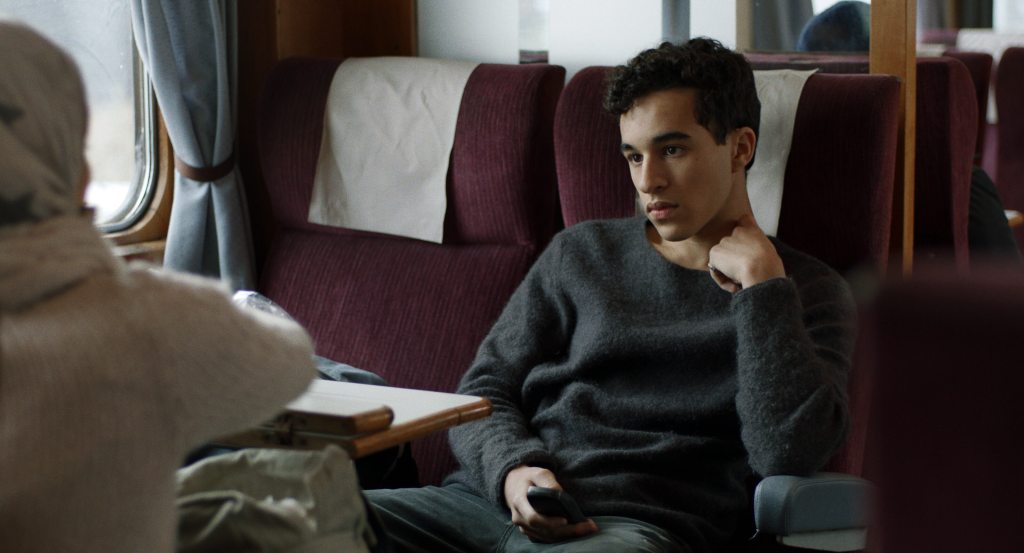 Ahmad sits across the aisle on an overnight train in The Night Train, Jerry Carlsson's award-winning LGBTQ romantic short film.