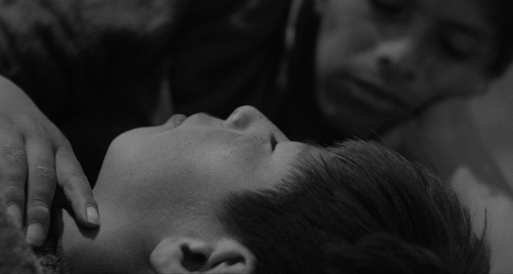 Two young men share an intimate moment in the gay short film Takanakuy, streaming on Dekkoo.