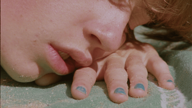 Arthur resting on the beach in The Blue Shelter, a French gay coming-of-age short film on Dekkoo