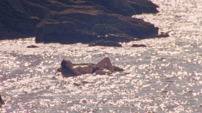 Arthur floating in the sea in The Blue Shelter, a French gay short film streaming on Dekkoo