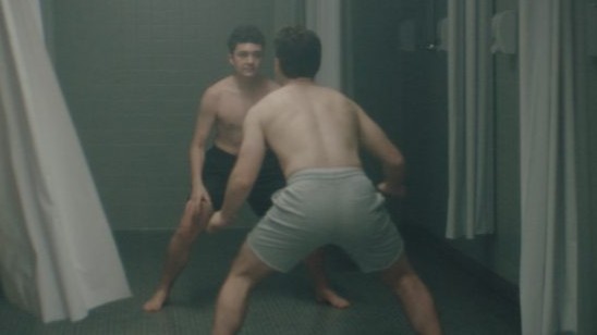 Leo and Kai playfully face off in their underwear in a locker room scene from the gay short film LEO.