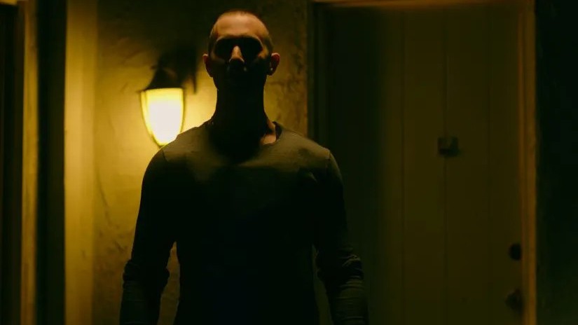A shadowy figure stands in a doorway in the queer thriller The Prodigy